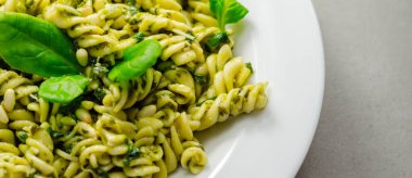 Pesto ve çam fıstıklı makarna salatası, regato peynirli fusilli makarna ve fesleğen soslu bebek ıspanağı, İtalyan yemeği.