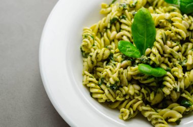 Pesto ve çam fıstıklı makarna salatası, regato peynirli fusilli makarna ve fesleğen soslu bebek ıspanağı, İtalyan yemeği.