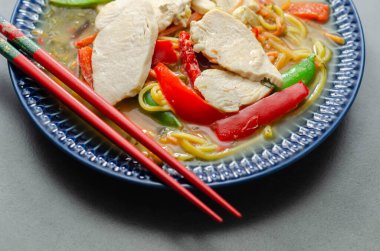 Zencefilli ve siyah mantarlı tavuk çorbası, yüksek proteinli buğday eriştesi, buğulanmış tavuk göğsü, jülyen havucu, kırmızı biber ve bezelye, ramen.