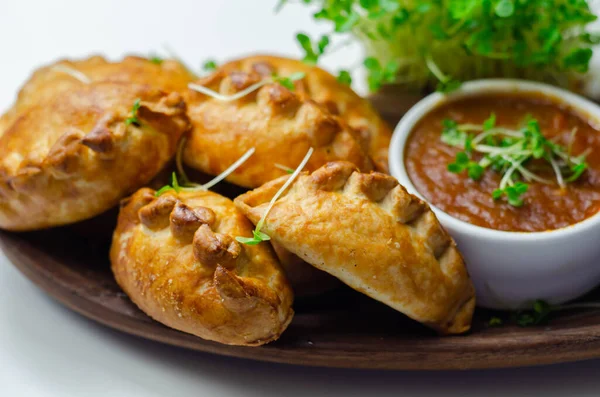 Domates soslu mini börekler, leziz domuz eti, hindi, domuz pastırması ve yaban mersini, hepsi kıtır hamura sarılmış, lezzetli yiyecekler.