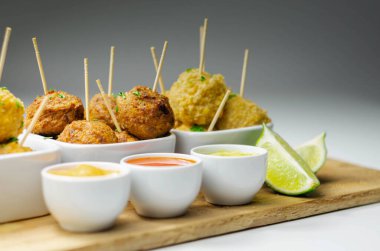 Çeşitli tavuk kivileri ve soslu tatlı patates falafları, ziyafet yemekleri.