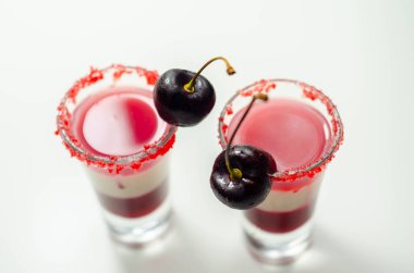 Votka, kiraz likörü ve bardakta şurup içeren üç katmanlı kokteyl. Taze kiraz ve kırmızı şeker ile süslenmiş. Renkli içki.