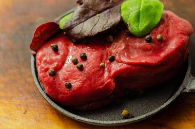 Kızartma, özel ve pahalı et için küçük bir tavada baharatlı çiğ biftek fileto.