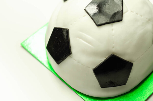 Football cake, sponge filled with frosting and raspberry jam, finished with soft icing and edible decorations, cake for a football player