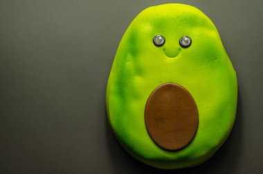 Avokado şeklinde vejetaryen pastası, çikolata soslu, yeşil yumuşak krema ve yenilebilir süslemelerle kaplı, parti pastası.