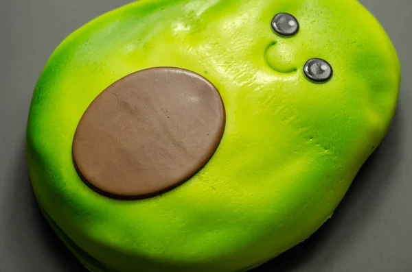 一种鳄梨形状的蛋糕 带有一层巧克力味的海绵 上面涂满了绿色软糖和可食用的装饰 还有派对蛋糕 — 图库照片