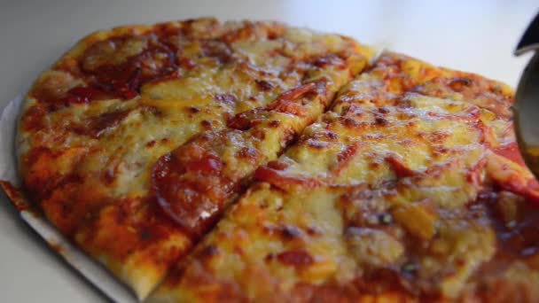 Corte de pizza com molho de tomate, mussarela e queijo cheddar, pimentão, chouriço e salame — Vídeo de Stock