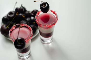 Votka, kiraz likörü ve bardakta şurup içeren üç katmanlı kokteyl. Taze kiraz ve kırmızı şeker ile süslenmiş. Renkli içki.