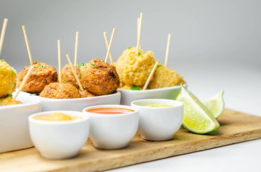 Çeşitli tavuk kivileri ve soslu tatlı patates falafları, ziyafet yemekleri.