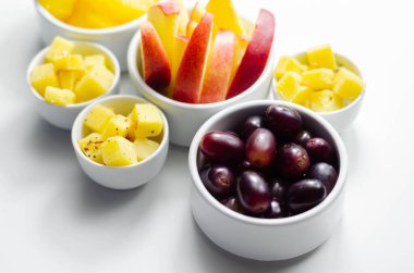 Çeşitli meyveler, ananas, elma, olgun çedar peynirli üzümler, sağlıklı atıştırmalıklar.