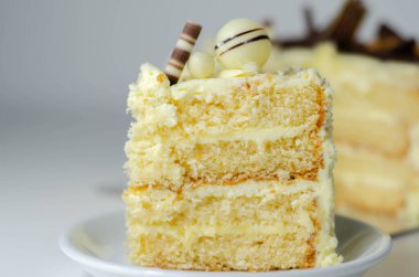 Bir parça katmanlı beyaz kremalı pasta, şekerleme süslemeleri, kutlama için tatlı.