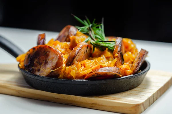 Lahana turşusu, sosis ve mantardan yapılmış geleneksel Polonya yemeği, dökme demir bir tavada sıcak servis edilen yemekler, Doğu Avrupa yemekleri.