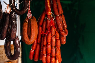Tipik İspanyol sosisleri gıda pazarında bir köy tezgahında asılı duruyor, geleneksel et ürünleri.