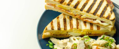 Kayın ağacından yapılmış pastırma, yumurta, mayonez ve domatesli beyaz ekmek. Parmesan peynirli Sezar makarnası, mavi tabak, sabah yemeği.