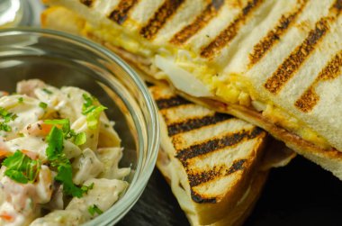 Kayın ağacından yapılmış pastırma, yumurta, mayonez ve domatesli beyaz ekmek. Parmesan peynirli Sezar makarnası, sabah yemeği.