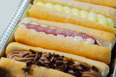 Çikolata, muhallebi, reçel ve krema dolu karışık parmak çörekleri, farklı tatlarda eklentiler, şekerlemeler