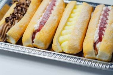 Çikolata, muhallebi, reçel ve krema dolu karışık parmak çörekleri, farklı tatlarda eklentiler, şekerlemeler