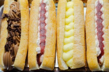 Çikolata, muhallebi, reçel ve krema dolu karışık parmak çörekleri, farklı tatlarda eklentiler, şekerlemeler