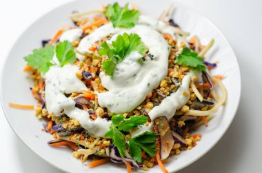 Soslu lahana salatası ve kızarmış ekmekler brokoli, havuç, kırmızı lahana ve soğan beyaz tabakta, sağlıklı yiyecekler.