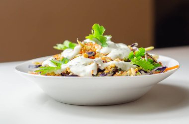 Soslu lahana salatası ve kızarmış ekmekler brokoli, havuç, kırmızı lahana ve soğan beyaz tabakta, sağlıklı yiyecekler.