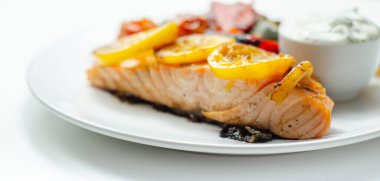 Kızarmış sebzeli ızgara somon filetosu, salatalık ve dereotu sosu, sağlıklı yiyecekler.