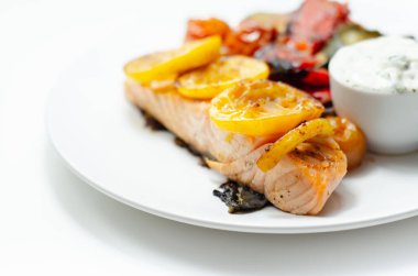 Kızarmış sebzeli ızgara somon filetosu, salatalık ve dereotu sosu, sağlıklı yiyecekler.