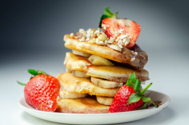 Muz, çilek ve fındık dolu krepler, üstüne çikolata ve çilek sosu, tatlı kahvaltı.