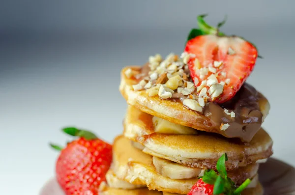 Pancake Ditumpuk Dengan Pisang Stroberi Dan Kacang Kacangan Diatapi Dengan — Stok Foto