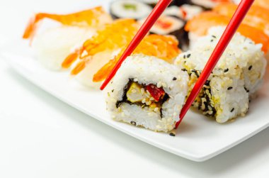 Tütsülenmiş somon nigiri, Ebi kralı nigiri, katsu tavuğu ve kırmızı biber California rulosu, wasabi hosomaki rollü salatalık ve kırmızı biberli hosomaki, geleneksel Japon yemekleri.