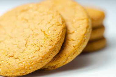 Beyaz arka planda bir yığın tarçınlı yulaflı kurabiyeye yaklaş, lezzetli ve sağlıklı bir atıştırmalık.