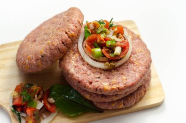 Çiğ sığır burger, karamelli kırmızı soğan ve keskin kırmızı Leicester peyniri ile harmanlanmış ızgara için hazırlanmış lezzetli yemekler.