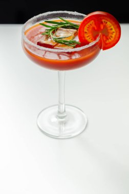 Saf votka, domates suyu ve acı biber sosuyla hazırlanmış Bloody Mary kokteyli. Bir dilim domatesle süslenmiş içki.