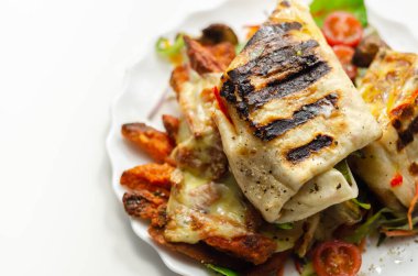 Izgara tortilla dürümü ve güney usulü tavuk göğsü. Karışık salatada servis edilen patates kızartması. Öğle yemeği vakti.