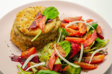 Eriyen çedar soslu füme mezgit balığı keki ve karışık salata, deniz ürünleri.