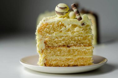 Bir parça katmanlı beyaz kremalı pasta, şekerleme süslemeleri, kutlama için tatlı.