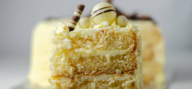 Bir parça katmanlı beyaz kremalı pasta, şekerleme süslemeleri, kutlama için tatlı.