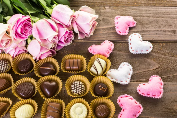 Chocolats assortis aux roses roses — Photo