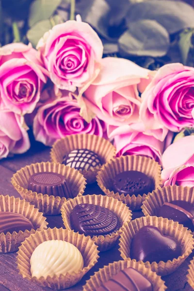 Chocolats assortis aux roses roses — Photo