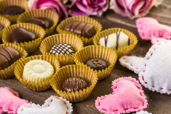 Chocolates variados com rosas rosa — Fotografia de Stock