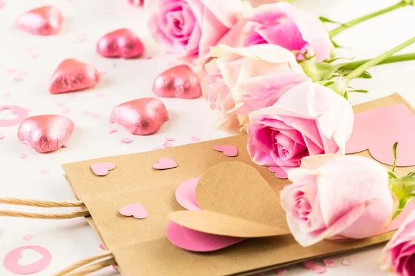 Pink roses and hand crafted gift bag — Stock Photo, Image