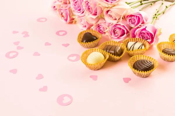 Chocolats assortis aux roses roses — Photo