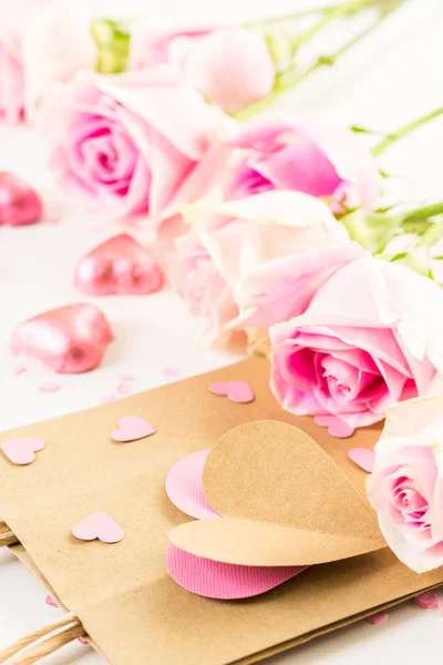 Růžové růže a ručně vytvořený taštička — Stock fotografie