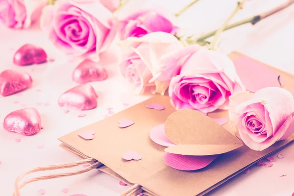 Pink roses and hand crafted gift bag — Stock Photo, Image