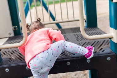 Oyun parkında oynayan yürümeye başlayan çocuk