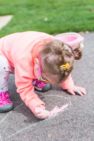 Toddler drawing with chalk on paved walk — Stock Photo, Image