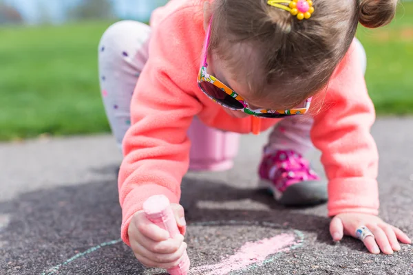 Peuter tekenen met krijt op verharde lopen — Stockfoto