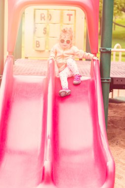 Toddler playing at the playground clipart