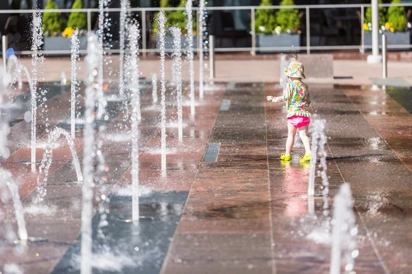 Kleinkind spielt mit Springbrunnen — Stockfoto