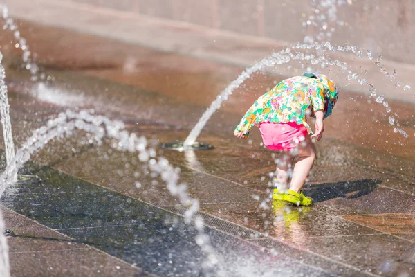 Kleinkind spielt mit Springbrunnen — Stockfoto