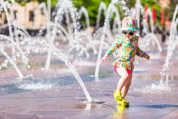 Kleinkind spielt mit Springbrunnen — Stockfoto
